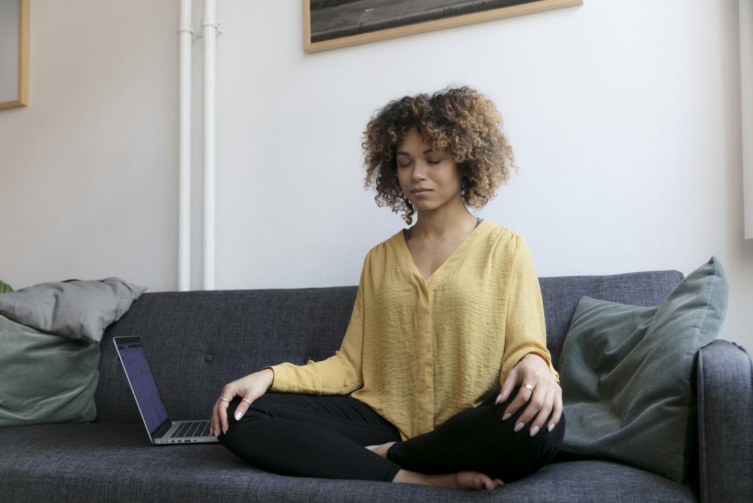 person meditating on the sofa