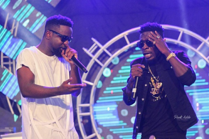 Sarkodie (white) and Shatta Wale perform together at a show