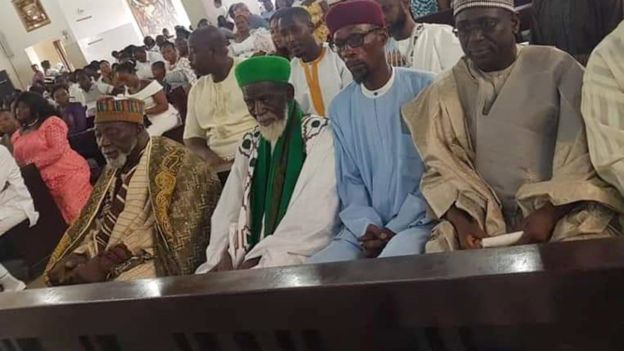 Sheikh Osman Sharubutu (C), in green, sitting in a pew at the Christ the King Catholic Church in Accra, Ghana