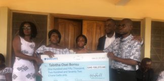 Acting Deputy Head of Business Development at First Insurance, Dela Hosu, presenting the cheque to the family