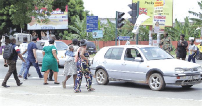 Pedestrains crossing the road in front of the 37 Military Hospital in Accra