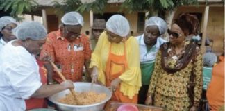 Cynthia Morrison being assisted by Dr Mrs Gertrude Quashigah to prepare the 'gari fotor