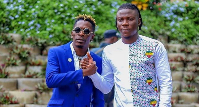 Shatta Wale (L) and Stonebwoy smoke the peace pipe