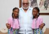 The twins in a photograph with former President John Rawlings