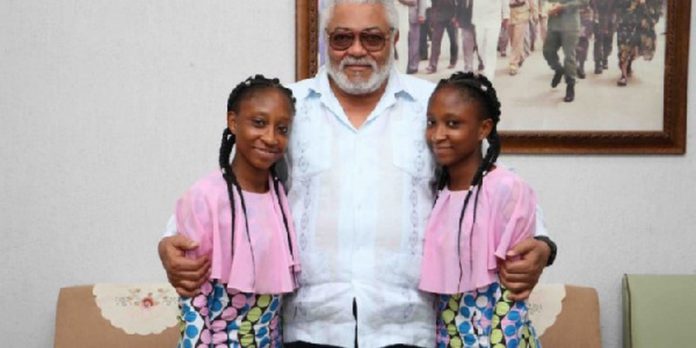 The twins in a photograph with former President John Rawlings