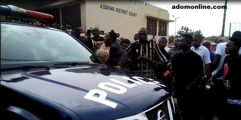 Relatives of the late Comfort Owusu gather around the vehicle transporting the two accused persons.