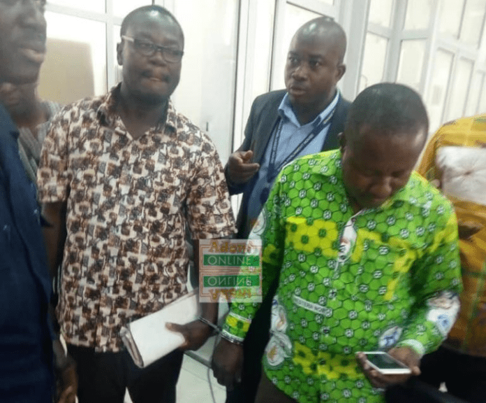 Forrmer District Finance Officer for sefwi Akontombra assembly Isaac Akowuah and the Current Officer James Esilfie in handcuffs being taken away by the police