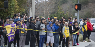 People gather on Las Virgenes Road in Calabasas near the scene of Sunday’s helicopter crash.(Mel Melcon / Los Angeles Times)