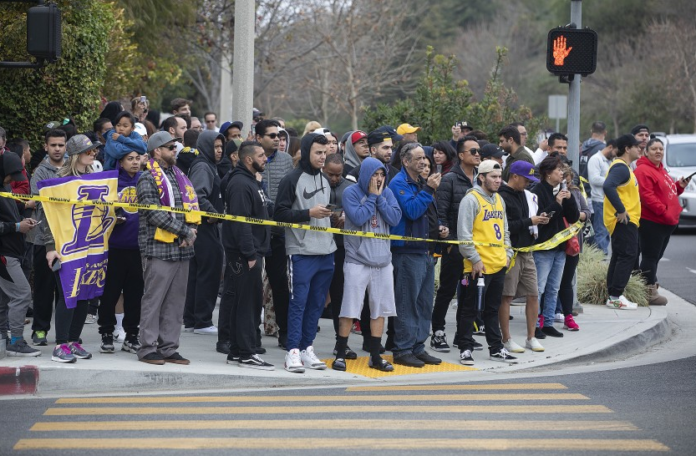 People gather on Las Virgenes Road in Calabasas near the scene of Sunday’s helicopter crash.(Mel Melcon / Los Angeles Times)