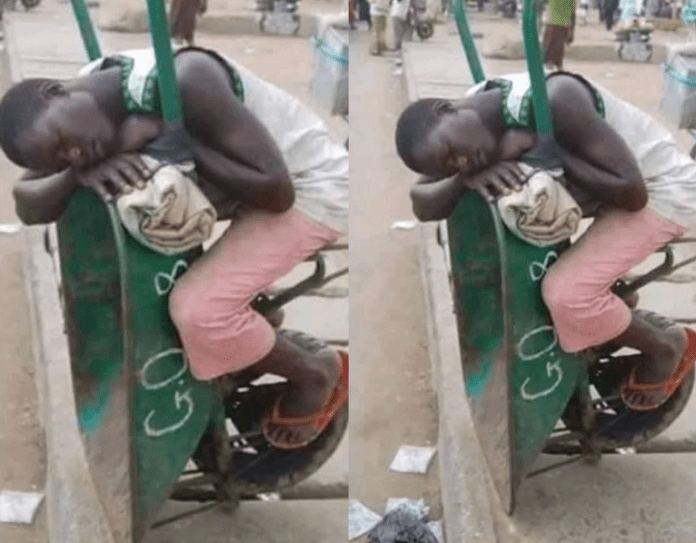 Man sleeping on a wheelbarrow