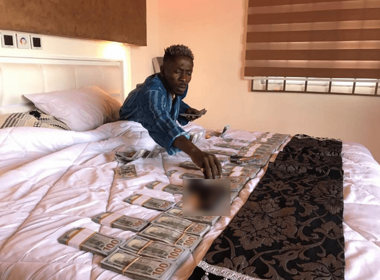 Shatta Wale shows off his money in bed