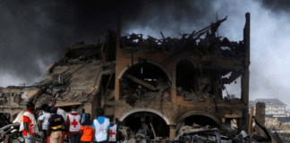 Paramedics and security men observe a building that was damaged by the pipeline explosion at Abule Ado in Lagos, Nigeria, March 15, 2020. (Reuters Photo)