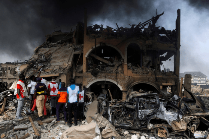 Paramedics and security men observe a building that was damaged by the pipeline explosion at Abule Ado in Lagos, Nigeria, March 15, 2020. (Reuters Photo)