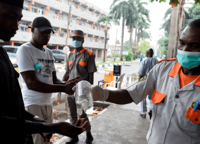 A security guard administering sanitizer to a hospital visitor in Lagos, Nigeria, on Friday.Credit...Pius Utomi Ekpei/Agence France-Presse — Getty Images