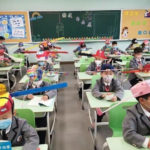 Children wear social distancing headgears as schools resume in China (photos)