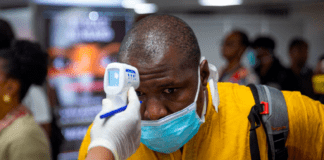 Man being checked with a gun thermometer at a checkpoint because of Coronavirus