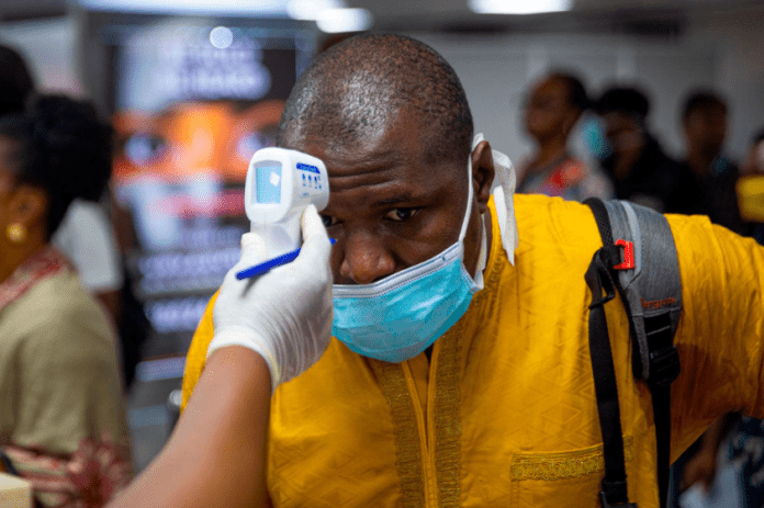 Man being checked with a gun thermometer at a checkpoint because of Coronavirus