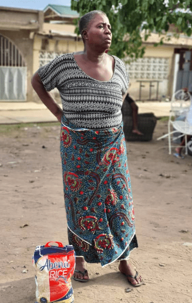 Old woman receives bag of rice from Amadia Foundation