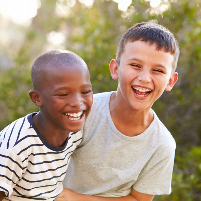 A black boy laughing with a white boy