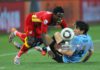 JOHANNESBURG, SOUTH AFRICA - JULY 02: Jorge Fucile of Uruguay tackles Samuel Inkoom of Ghana during the 2010 FIFA World Cup South Africa Quarter Final match between Uruguay and Ghana at the Soccer City stadium on July 2, 2010 in Johannesburg, South Africa. (Photo by Clive Rose/Getty Images)