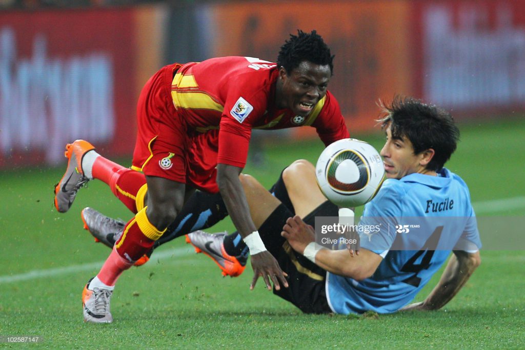 JOHANNESBURG, SOUTH AFRICA - JULY 02: Jorge Fucile of Uruguay tackles Samuel Inkoom of Ghana during the 2010 FIFA World Cup South Africa Quarter Final match between Uruguay and Ghana at the Soccer City stadium on July 2, 2010 in Johannesburg, South Africa. (Photo by Clive Rose/Getty Images)