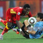 JOHANNESBURG, SOUTH AFRICA - JULY 02: Jorge Fucile of Uruguay tackles Samuel Inkoom of Ghana during the 2010 FIFA World Cup South Africa Quarter Final match between Uruguay and Ghana at the Soccer City stadium on July 2, 2010 in Johannesburg, South Africa. (Photo by Clive Rose/Getty Images)