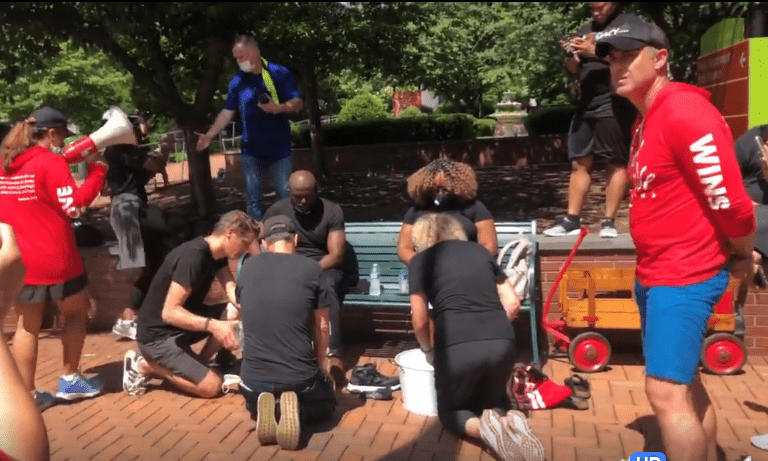 Faith and Soboma Wokoma, who helped host the event, sat down on a park bench and members of the community surrounded them, washing their feet while asking for forgiveness. Source: Tori Bush