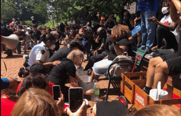 Faith and Soboma Wokoma, who helped host the event, sat down on a park bench and members of the community surrounded them, washing their feet while asking for forgiveness. Source: Tori Bush