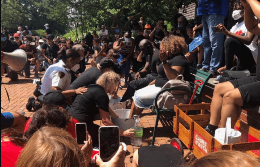 Faith and Soboma Wokoma, who helped host the event, sat down on a park bench and members of the community surrounded them, washing their feet while asking for forgiveness. Source: Tori Bush