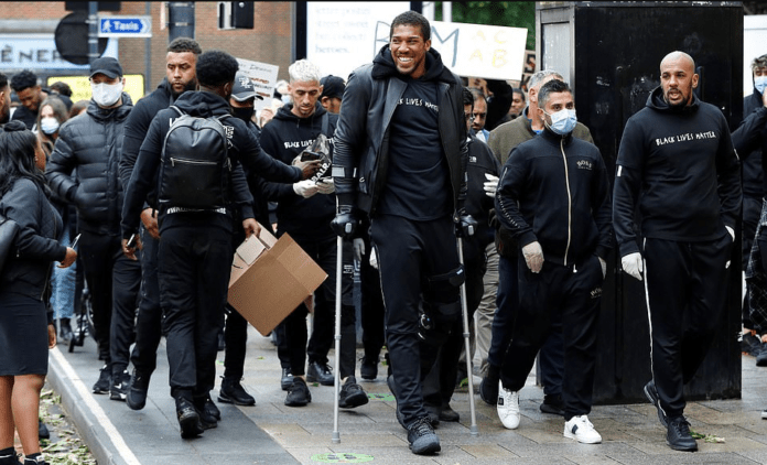 Anthony Joshua hobbles on crutches as he joins Black Lives Matter protest