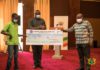 Nana Addo Dankwa Akufo-Addo presenting a cheque to a beneficiary