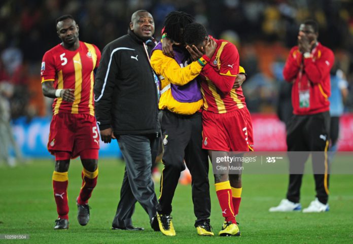 JOHANNESBURG, SOUTH AFRICA – JULY 02: Asamoah Gyan is consoled by Derek Boateng after Ghana are knocked out in a penalty shoot-out during the 2010 FIFA World Cup South Africa Quarter Final match between Uruguay and Ghana at the Soccer City stadium on July 2, 2010, in Johannesburg, South Africa. (Photo by Clive Mason/Getty Images)