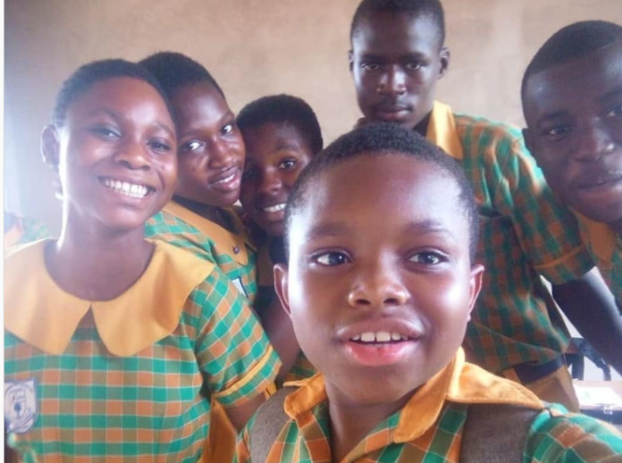 Gideon Nhyiraba and some of his classmates take a picture after writing BECE