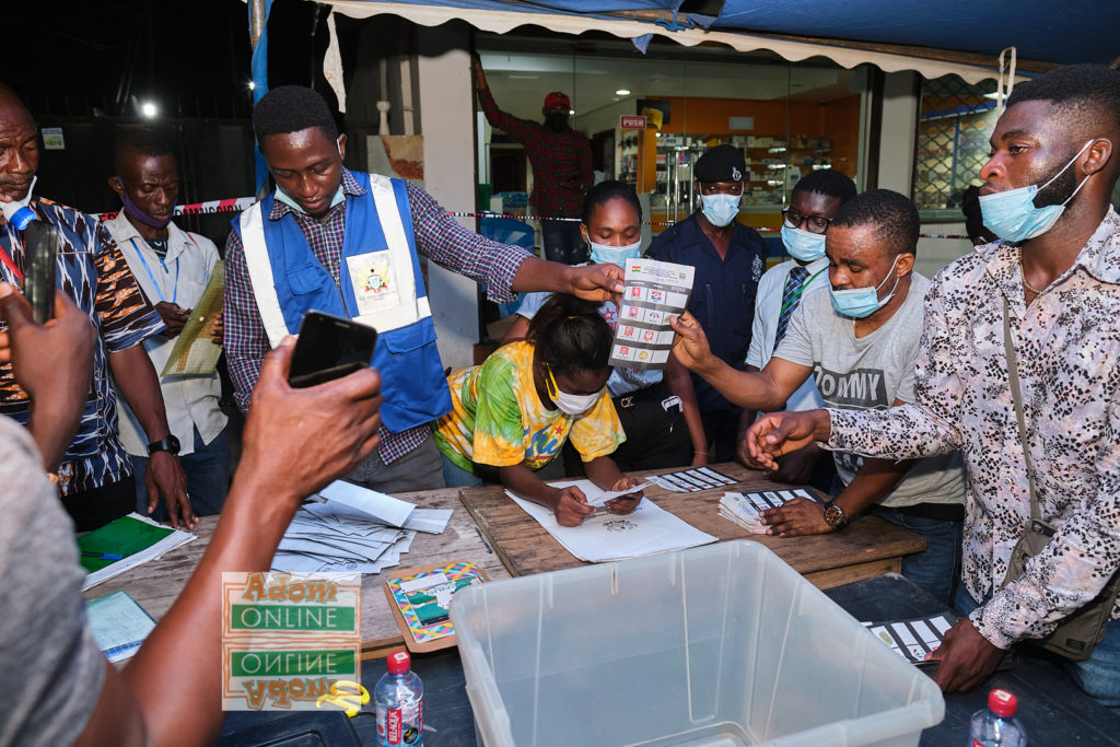 EC Officials collate results as party officials look on 