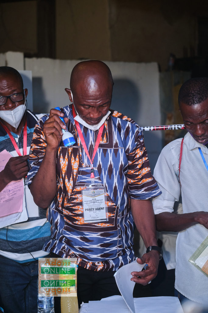 EC Official inspects voting booklet with his torchlight at Ayawaso West Wuogon