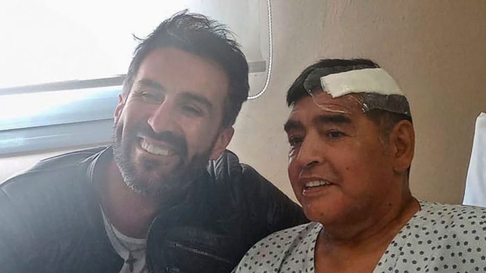 THIS HANDOUT PHOTO RELEASED BY THE PRESS OFFICER FOR DIEGO ARMANDO MARADONA SHOWS THE ARGENTINE FOOTBALL LEGEND SHAKING HANDS WITH HIS DOCTOR, LEOPOLDO LUQUE, AT THE OLIVOS CLINIC