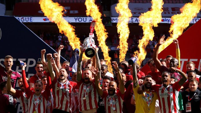 Pontus Jansson of Brentford lifts the Sky Bet Championship Play Off Trophy following victory in the Sky Bet Championship Play-off Final between Brentford FC and Swansea City at Wembley Stadium on May 29, 2021 in London, England. Image credit: Getty Images