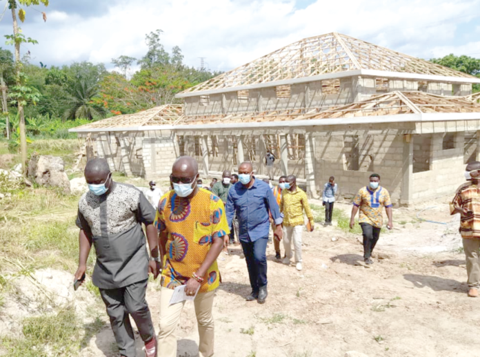 Mr Alexander Frimpong (left), District Chief Executive for Asante Akim, with Nii Lantey Vanderpuiye after inspecting work on a court complex in the municipality