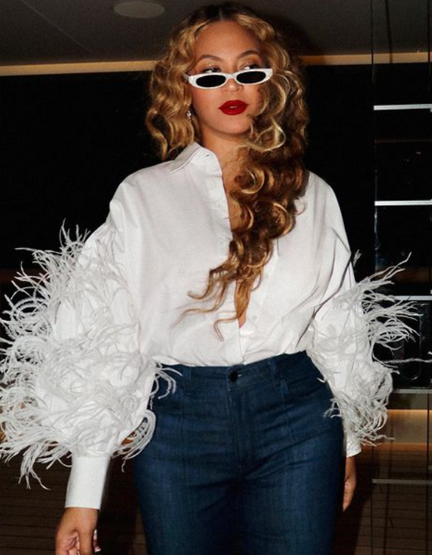 Beyonce accessorized with a pair of white-rimmed dark shades and carried a champagne-like bag, while her long blonde hair was styled in curls. 