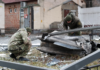 Police officers inspect the remains of a missile that fell in the street, after Russian President Vladimir Putin authorized a military operation in eastern Ukraine, in Kyiv, Ukraine February 24, 2022 [Valentyn Ogirenko/Reuters]