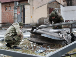 Police officers inspect the remains of a missile that fell in the street, after Russian President Vladimir Putin authorized a military operation in eastern Ukraine, in Kyiv, Ukraine February 24, 2022 [Valentyn Ogirenko/Reuters]