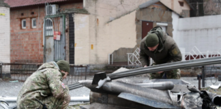 Police officers inspect the remains of a missile that fell in the street, after Russian President Vladimir Putin authorized a military operation in eastern Ukraine, in Kyiv, Ukraine February 24, 2022 [Valentyn Ogirenko/Reuters]