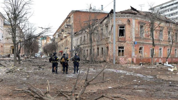 Ukrainian police officers patrol a street following shelling in Ukraine's second-biggest city of Kharkiv (Image: AFP via Getty Images)