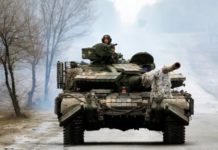 Ukrainian servicemen ride on tanks toward the front line with Russian forces in the Luhansk region of Ukraine on Friday. The president has waived entry visa requirements for any foreigners who want to join the fight against Russia. (Anatolii Stepanov/AFP via Getty Images)