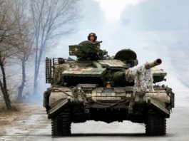 Ukrainian servicemen ride on tanks toward the front line with Russian forces in the Luhansk region of Ukraine on Friday. The president has waived entry visa requirements for any foreigners who want to join the fight against Russia. (Anatolii Stepanov/AFP via Getty Images)