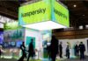 People walk next to Russian Kaspersky stand during the GSMA's 2022 Mobile World Congress (MWC), in Barcelona, Spain, March 2, 2022. REUTERS/ Albert Gea/File Photo