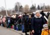 People wait to board a bus at the border checkpoint in Medyka after fleeing Ukraine - Reuters/Yara Nardi