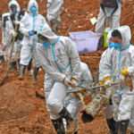 Rescuers carry a piece of plane wreckage at the site of the March 21 crash in southern China's Guangxi province. (Zhou Hua/AP)