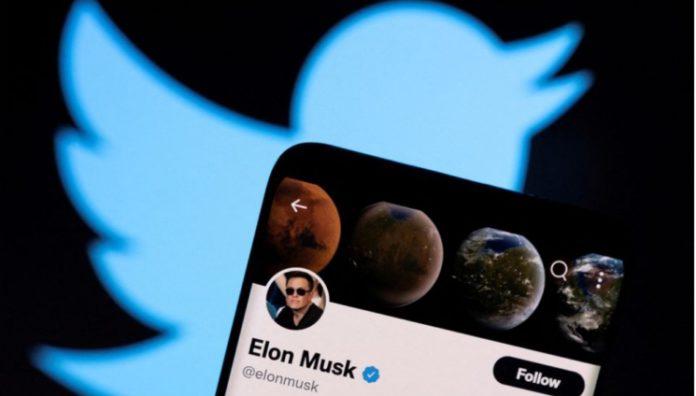 Elon Musk's twitter account is seen on a smartphone in front of the Twitter logo in this photo illustration taken, April 15, 2022. REUTERS/Dado Ruvic/Illustration/File Photo