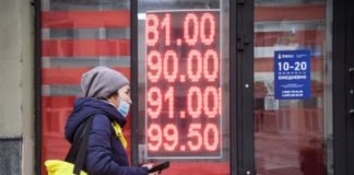 A woman walks past a currency exchange office in central Moscow on Feb. 24. Alexander Nemenov/AFP via Getty Images